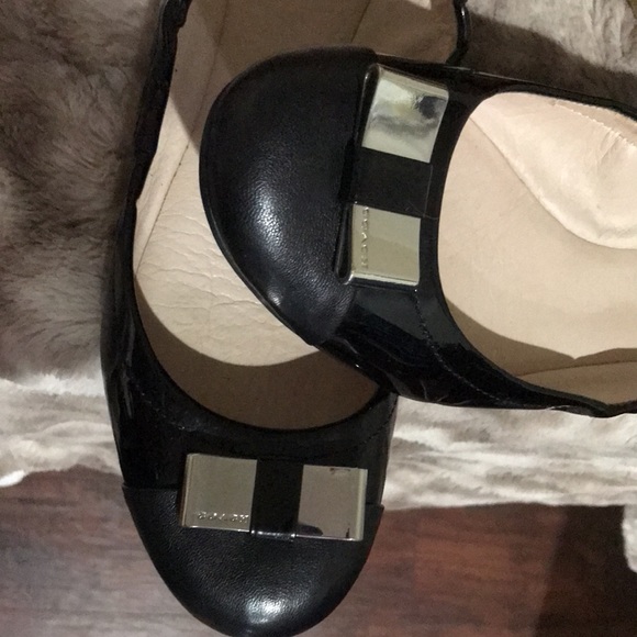 Coach Shoes - Coach black women flats 🥿 size 8B with a silver bow detail.